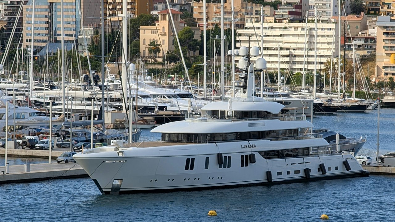 A large white yacht docked in a marina